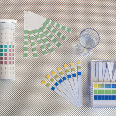 water analysis kit, ph test strips and total hardness test strips and a test tube with water