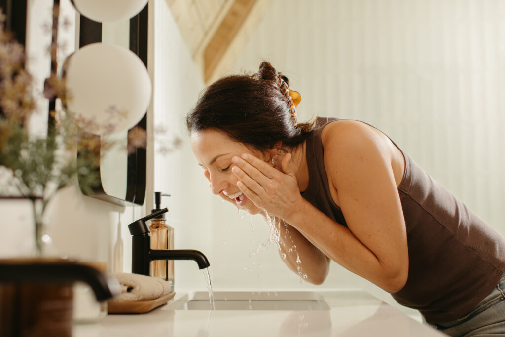 Lady washing face with soft water 